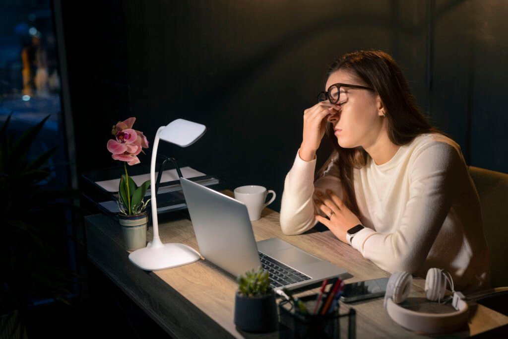 Imagem atual: Woman experiencing eye strain at a desk before using monitor light bars